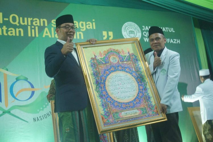 Gubernur Jabar terpilih Ridwan Kamil diberi hadiah kaligrafi karya peserta MTQ Internasional di Ponpes Asshiddqiyah 3 Karawang, Minggu (15/7/2018) malam.