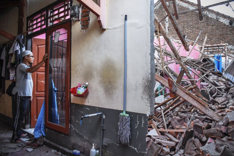 Seorang laki-laki melihat rumahnya yang sebagian temboknya roboh pascagempa bumi di Dusun Lendang Bajur, Kecamatan Gunungsari, Lombok Barat, NTB, Senin (6/8/2018). Gempa bumi bermagnitudo 7 mengguncang Lombok, Minggu (5/8/2018) malam. 