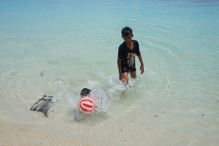 Seorang anak sedang bermain bola di pantai Wambar Fakfak Papua Barat