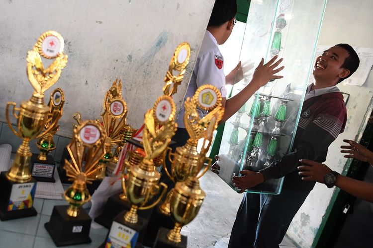 Siswa berbenah saat hari pertama masuk sekolah di SMA Negeri 2, Palu, Sulawesi Tengah, Senin (8/10). Pihak sekolah melakukan pendataan pada hari pertama sekolah untuk mengetahui jumlah siswa pascagempa dan tsunami.