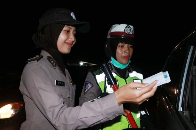 Polisi wanita dari Polres Aceh Utara memeriksa surat kendaraan bermotor di Kompleks Terminal Lhoksukon, Kabupaten Aceh Utara, Sabtu (29/12/2018) malam.