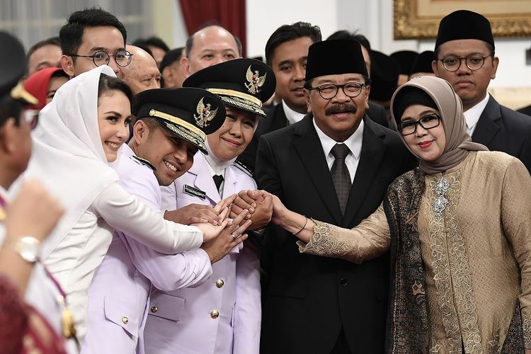 Gubernur Jawa Timur Khofifah Indar Parawansa (tengah) berfoto bersama Wakil Gubernur Jawa Timur Emil Dardak (dua kiri) dan istri Arumi Bacshin (kiri) dan mantan Gubernur Jawa Timur Soekarwo (kedua kanan) dan istri usai usai pelantikan di Istana Negara, Jakarta, Rabu (13/2/2019). Presiden melantik Gubernur dan Wakil Gubernur Jawa Timur Khofifah Indar Parawansa-Emil Dardak untuk periode 2019-2024 dan Gubernur Jambi Fachrori Umar untuk masa jabatan hingga 2021. ANTARA FOTO/Puspa Perwitasari/pd.