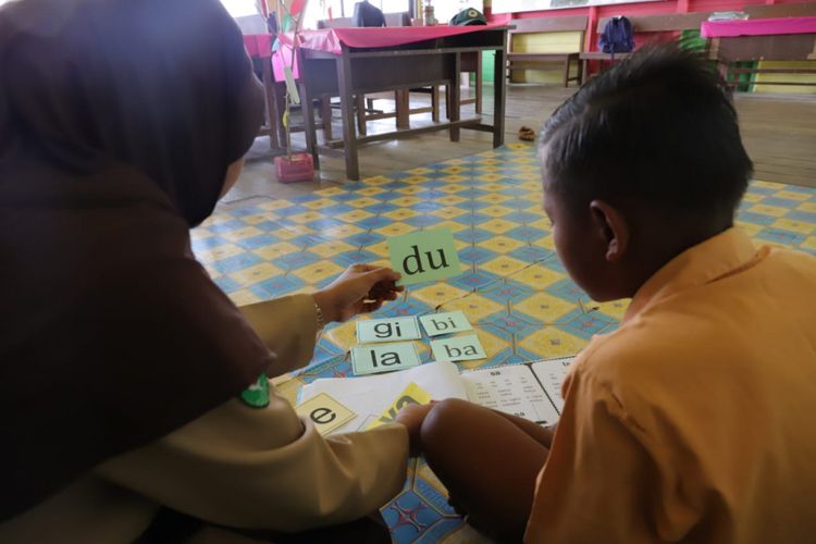Warsiah, Kepala SDN 013 Desa Bulu Perindu, Kecamatan Tanjung Selor, Kalimantan Utara memberikan bimbingan membaca kepada siswa dengan metode kartu baca.