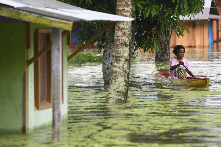 Seorang warga mendayung perahu ketika mengamankan barang berharga miliknya dari permukimannya yang terendam banjir bandang di sekitar Danau Sentani, Jayapura, Papua, Selasa (19/3/2019). Akibat banjir bandang yang melanda Sentani sejak Sabtu (16/3) lalu, jumlah warga yang mengungsi ke sejumlah posko pengungsian bertambah menjadi sedikitnya enam ribu orang. ANTARA FOTO/Zabur Karuru/wsj.