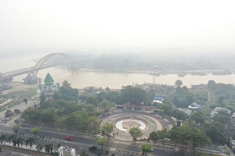 Foto udara Sungai Kahayan yang diselimuti kabut asap di Palangka Raya, Kalimantan Tengah, Jumat (26/7/2019). Kebakaran hutan dan lahan yang terjadi di Palangka Raya menyebabkan kabut asap yang cukup tebal disertai dengan bau asap yang sangat menyengat. ANTARA FOTO/Hafidz Mubarak A/nz.