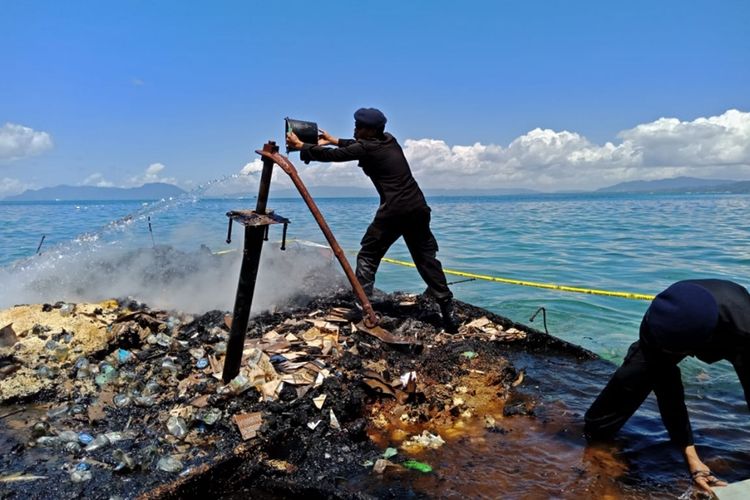 Anggota Brimobda dan Pol Air Polda Sultra berusaha memadamkan sisa api yang telah membakar KM Izhar di perairan Pulau Bokori, Kabupaten Konawe, Sultra.
