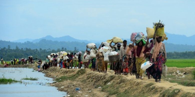 Para pengungsi Rohingya berjalan menyusuri daerah tak bertuan antara Bangladesh dan Myanmar di kawasan Palongkhali. Foto ini diambil pada 19 Oktober 2017.