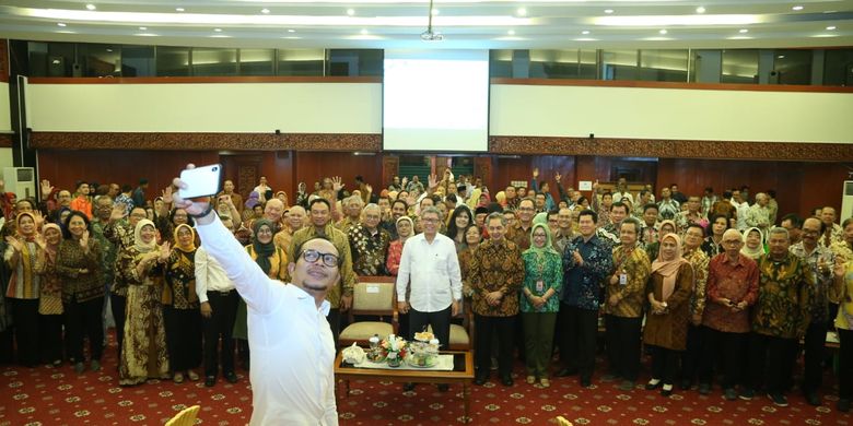 Menteri Ketenagakerjaan (Menaker) M. Hanif Dhakiri berswafoto dengan latar para pensiunan pegawai ASN Kementerian Ketenagakerjaan (Kemnaker), Senin (1/4/2019).