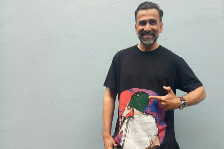 Jeremy Thomas memamerkan t-shirt yang dirancang oleh  putranya, Axel Matthew Thomas, ketika ditemui di Gedung Trans, kawasan Tendean, Jakarta Selatan, Senin (13/11/2017).