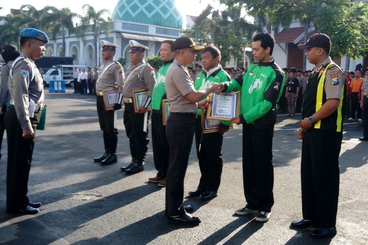 Mahardhika Nugraha Hariyanto, pengemudi Go-Jek, dan rekannya menerima penghargaan dari Kapolrestabes Surabaya karena aksi heroiknya mengejar dua penjambret sehingga bisa tertangkap.