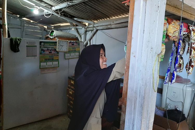 Nining Suryani (44) menunjukkan isi rumahnya yang menempati bagian toilet sekolah di SDN Karyabuana 3, Kecamatan Cigeulis, Kabupaten Pandeglang, Banten, Senin (15/7/2019)