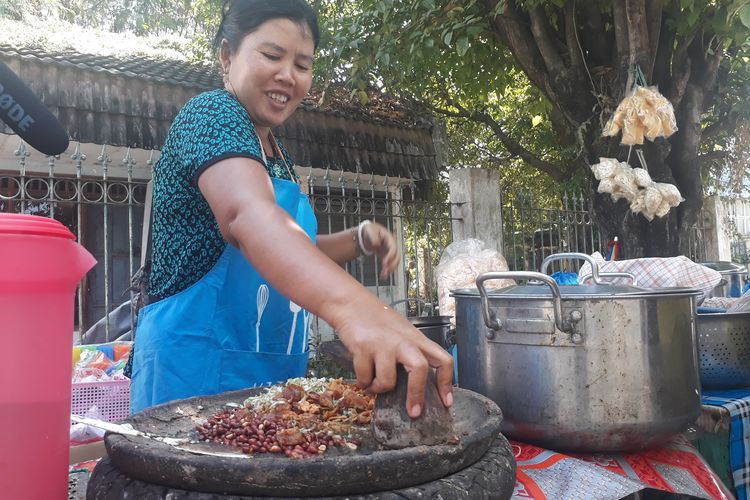 Ibu Mella, penjual rujak cingur seharga Rp 60.000 di Wiguna Timur, Kelurahan Gunung Anyar, Kecamatan Rungkut, Surabaya, melayani pembeli, Rabu (12/6/2019). 
