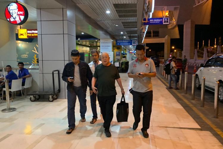 Hasan Basri (tengah) saat dijemput di bandara Sultan Hasanuddin Makassar oleh tim gabungan kepolisian Polda Sulsel dan Polres Pelabuhan Makassar usai menodongkan pistol di depan wajah pedagang MTC, Minggu (26/5/2019) malam. 