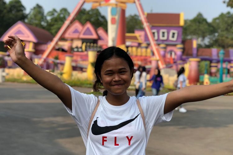 Dewi Febriyanti (13) tersenyum bahagia ketika diundang bermain ke Dunia Fantasi, Ancol pada Minggu (28/7/2019).
