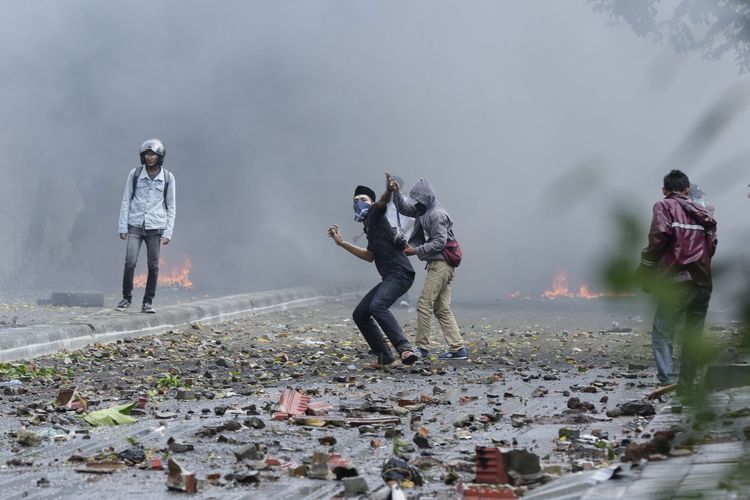 Massa melempari batu  saat terjadi kericuhan di Jalan Brigjen Katamso, Jakarta, Rabu (22/5/2019). Kericuhan terjadi sejak selasa (21/5/2019) malam dan berlangsung hingga Rabu siang