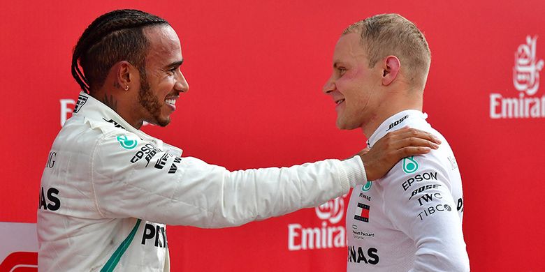 Pebalap Mercedes Lewis Hamilton (kiri) berbicara dengan rekan setimnya yang meraih posisi kedua, Valtteri Bottas, usai menjalani balapan Formula 1 (F1) GP Jerman yang berlangsung di Hockenheimring, Hockenheim, Jerman, Minggu (22/7/2018). Kemenangan diraih pebalap Mercedes Lewis Hamilton secara dramatis setelah mengawali balapan dari urutan ke-14.