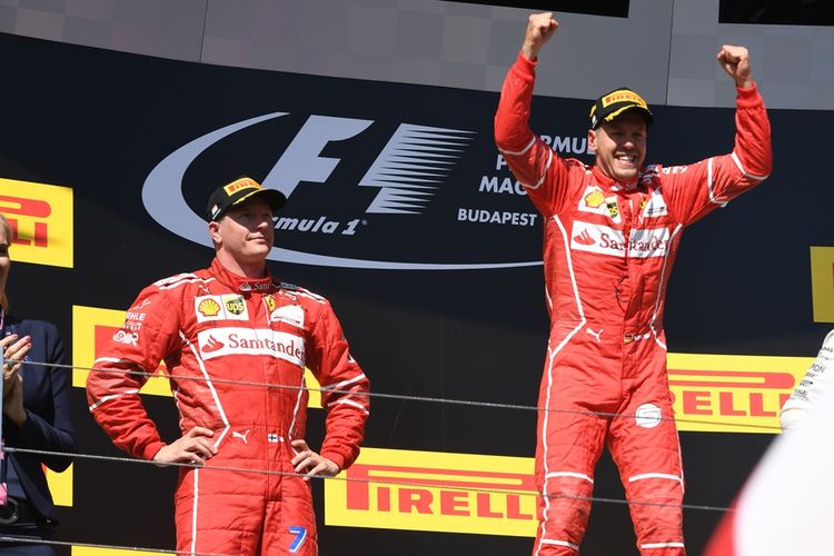 Pebalap Ferrari asal Jerman, Sebastian Vettel (kanan), merayakan kemenangan pada balapan GP Hongaria di Hungaroring, Minggu (30/7/2017). Rekan satu timnya, Kimi Raikkonen (kiri), finis di urutan kedua.