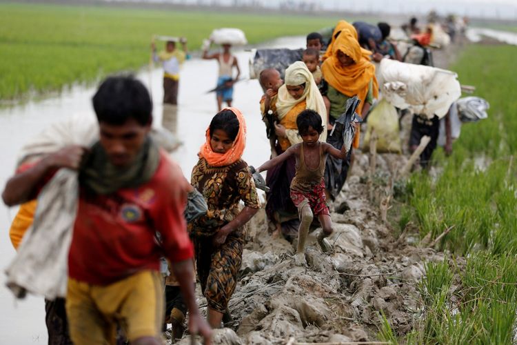 Pengungsi Rohingya berjalan di jalan berlumpur setelah menyeberangi perbatasan Banglades-Myanmar di Teknaf, Banglades, Minggu (3/9/2017).