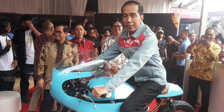 Presiden Joko Widodo menaiki salah satu sepeda motor Honda CB 125 lawas yang dipamerkan di stan Increase saat berlangsungnya hari pertama pameran Indonesia International Motor Show (IIMS) 2018, di JIExpo Kemayoran, Jakarta, Kamis (19/4/2018). Motor yang dimodifikasi bergaya caferacer merupakan milik putra sulung Jokowi, Gibran Rakabuming.