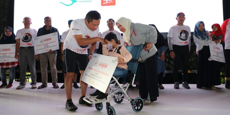 Direktur Utama Telkom Ririek Adriansyah (kiri) menyerahkan simbolis donasi kepada penderita kanker darah dalam acara Bike to Care IndiHome, di Jakarta, Rabu (4/9/2019).