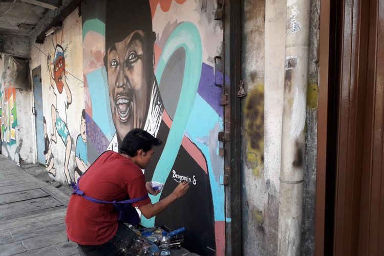 Seorang seniman tengah melukis mural bergambar sosok Benyamin Sueb di Kampung Sketsa Tematik di Penjaringan, Selasa (31/7/2018). 