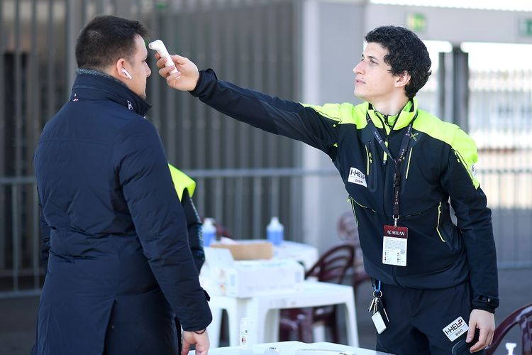 Staf memeriksa suhu badan seorang pria sebelum masuk ke stadion di San Siro, Milan, Italia, Minggu (8/3/2020). Pertandingan antara AC Milan melawan Genoa dilaksanakan di ruang tertutup untuk penonton saat jumlah kasus positif virus korona semakin meningkat. ANTARA FOTO/REUTERS/Daniele Mascolo/hp/cfo