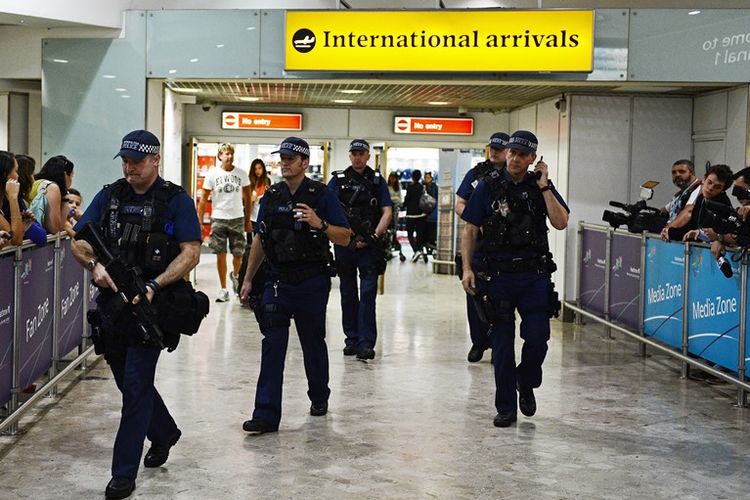 Kepolisian Inggris berjaga di terminal kedatangan bandara internasional Heathrow, London.