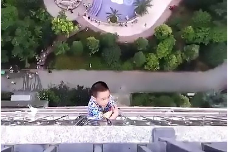 Seorang bocah terjatuh dari apartemennya dan begelantungan di lantai 19 sebuah gedung permukiman di Shenzen, China.