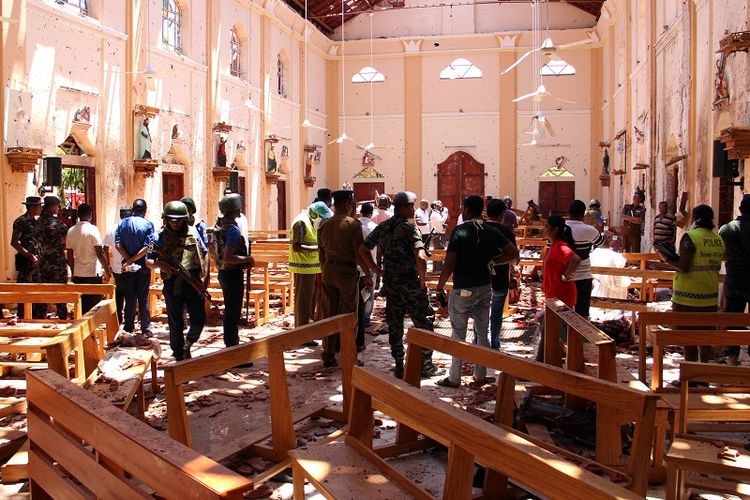 Aparat keamanan Sri Lanka berjalan di antara puing di dalam gereja St Sebastian, Negombo, sebelah utara Kolombo. Gereja ini menjadi salah satu tempat yang menjadi sasaran ledakan pada Minggu (21/4/2019). 