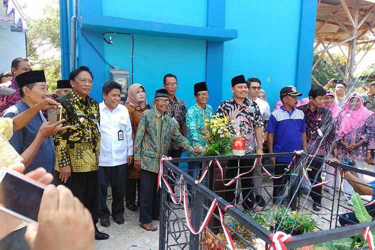 Bupati Gresik Sambari Halim Radianto beserta petinggi Desa Pangkahkulon dan perwakilan PGN Saka, saat peresmian jaringan air bersih, Kamis (2/8/2018).