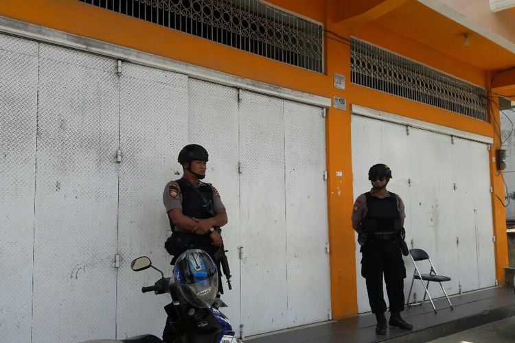 Dua anggota kepolisian dari Polda Sultra mengawal proses pengeledahan di kantor PT Manunggal Surya Sarana Pratama oleh KPK di Kendari, terkait kasus dugaan korupsi mantan Bupati Konawe Aswad Sulaiman(KOMPAS.COM/KIKI ANDI PATI)