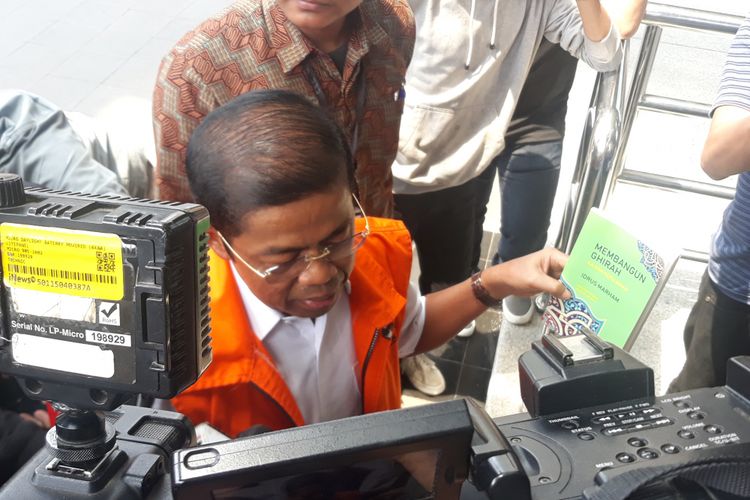 Idrus Marham menunjukkan buku karyanya sendiri sebelum menjalani pemeriksaan sebagai tersangka di Gedung KPK Jakarta, Jumat (16/11/2018).