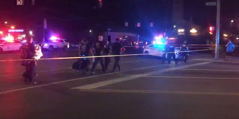 Potongan video ini diambil dari akun Twitter Derek Myers pada 4 Agustus 2019 memperlihatkan polisi berjalan di garis pengaman buntut terjadinya penembakan massal di kawasan bar dan tempat hiburan malam populer Oregon di Dayton, Ohio. Sebanyak 9 orang tewas dalam penembakan massal tersebut.