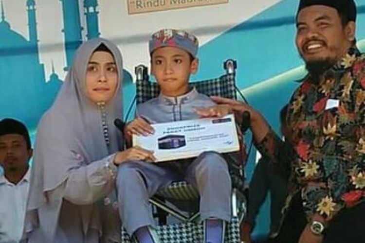Naja (9), anak penghafal 30 juz Al-Quran yang juga penderita lumpuh otak, mendapatkan hadiah umroh saat menghadiri acara haul 10 tahun meninggalnya Tuan Guru Wildan Khalil, pendiri Yayasan Darul Hikmah, Desa Darek, Lombok Tengah, Rabu (21/8/2019)