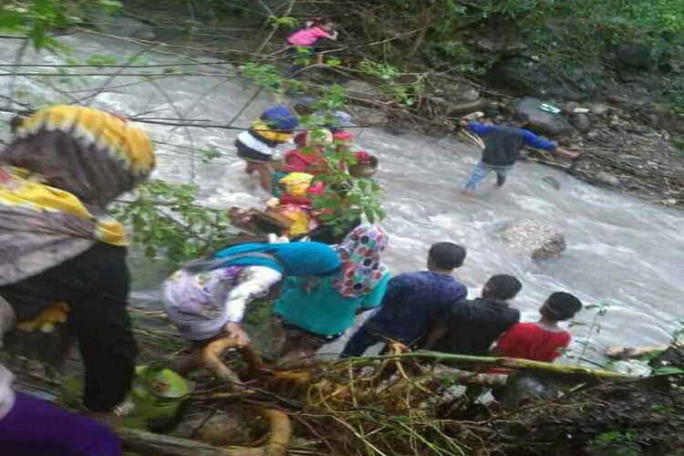 Sejumlah warga di Kabupaten Bone, Sulawesi Selatan berusaha mengungsi dengan cara nekat menorobos derasnya air sungai. Rabu, (20/6/2018).