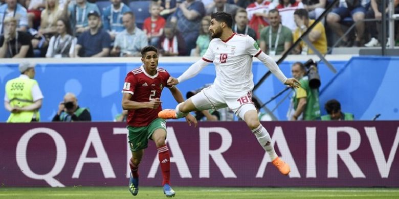 Bek Maroko Achraf Hakimi (merah) berduel dengan penyerang Iran Alireza Jahanbakhsh pada pertandingan Piala Dunia 2018 di Saint Petersburg, 15 Juni 2018. Hakimi merupakan pemain termuda Maroko sepanjang sejarah Piala Dunia. 