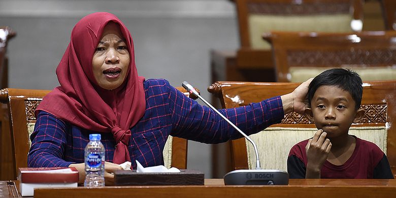 Terpidana kasus pelanggaran Undang-Undang Transaksi dan Informasi Elektronik (UU ITE), Baiq Nuril Maknun (kiri) didampingi anaknya menyampaikan tanggapan saat rapat pleno Komisi III DPR terkait surat persetujuan amnesti di Kompleks Parlemen Senayan, Jakarta, Selasa (23/7/2019). Rapat pleno tersebut untuk meminta tanggapan dari para fraksi terkait surat permohonan pertimbangan amnesti untuk Baiq Nuril dari Presiden Joko Widodo.