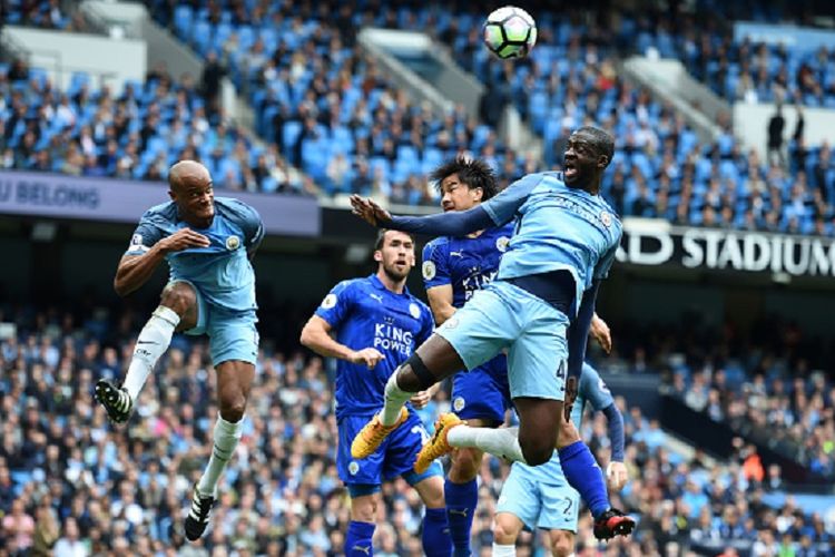 Striker Leicester City, Shinji Okazaki, mencoba memenangi duel udara menghadapi dua pemain Manchester City, Vincent Kompany dan Yaya Toure, dalam pertandingan Premier League di Stadion Etihad, Sabtu (13/5/2017). 
