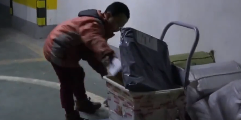 Li Changjiang nampak sedang memeriksa gerobak kecilnya yang dia gunakan untuk membawa paket. (Channel News Asia)