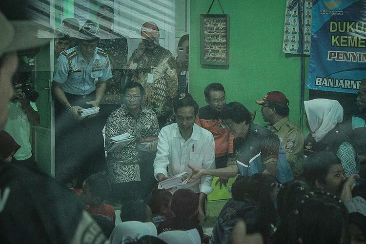 Presiden Joko Widodo (kiri) bersama Ketua Komisi Perlindungan Anak, Seto Mulyadi, membagikan buku tulis kepada anak-anak korban gempa di Posko Induk Desa Kasinoman, Kecamatan Kalibening, Banjarnegara, Jawa Tengah, Senin (23/4/2018). Gempa tektonik berkekuatan magnitudo 4,4 mengguncang wilayah tersebut pada Rabu, 18 April lalu, menewaskan sedikitnya dua orang dan melukai 21 lainnya.