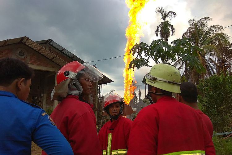 Petugas pemadam kebakaran berada di dekat lokasi kebakaran sumur minyak di Desa Pasi Putih, Kecamatan Ranto Peureulak, Kabupaten Aceh Timur, Rabu (25/4/2018). Sedikitnya 10 orang tewas dan belasan lainnya terluka akibat insiden meledaknya sumur minyak yang terjadi sekitar pukul 01.30 tersebut. .