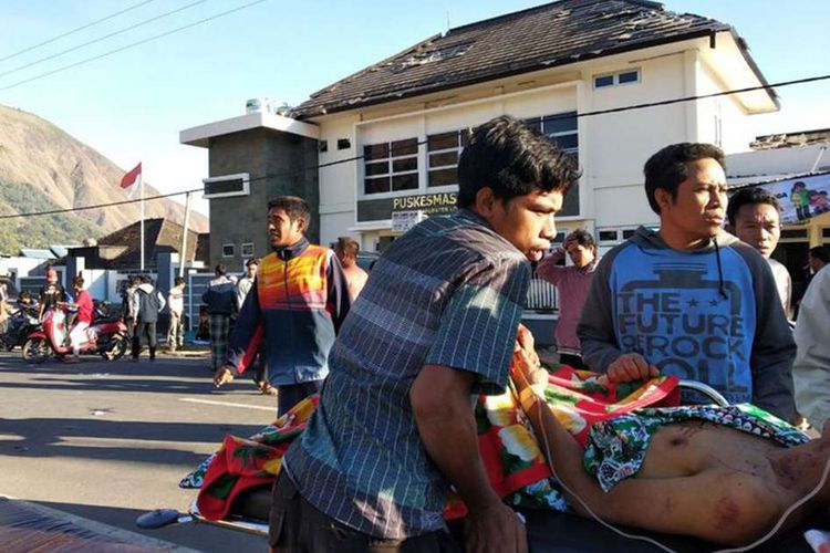 Warga korban gempa mendapatkan perawatan di luar sebuah puskesmas di Lombok, NTB, Minggu (29/7/2018). Berdasarkan informasi dari Badan Meteorologi Klimatologi dan Geofisika (BMKG) gempa pertama kali mengguncang Lombok Timur dengan kekuatan 6,4 skala Richter (SR) pada pukul 06.47 Wita.