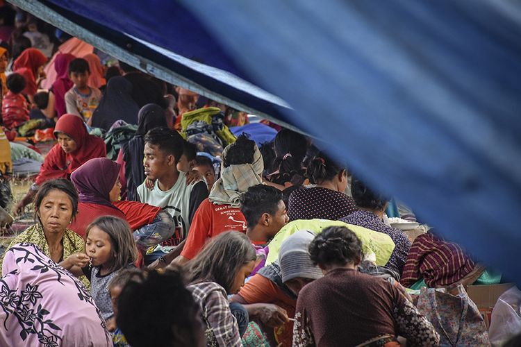 Sejumlah warga korban gempa berada di pengungsian di lapangan Desa Sajang, Kecamatan Sembalun, Selong, Lombok Timur, NTB, Minggu (29/7/2018). Para warga di Desa Sajang dan Desa Sembalun Bumbung memilih tidur di tenda pengungsian karena masih sering terjadinya gempa susulan yang menurut data stasiun Geofisika BMKG Mataram terjadi sebanyak 145 kali gempa susulan hingga terakhir pada pukul 17:45:04 Wita dengan magnitude 3.1.