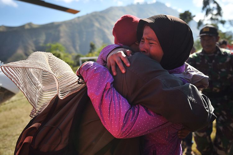 Pendaki Gunung Rinjani yang sempat terjebak longsor akibat gempa bumi, Suharti (kanan), berpelukan dengan adiknya setelah berhasil dievakuasi dan tiba di Lapangan Sembalun Lawang, Lombok Timur, NTB, Selasa (31/7/2018). Tiga orang pendaki yang terjebak akibat gempa berhasil dievakuasi menggunakan helikopter.