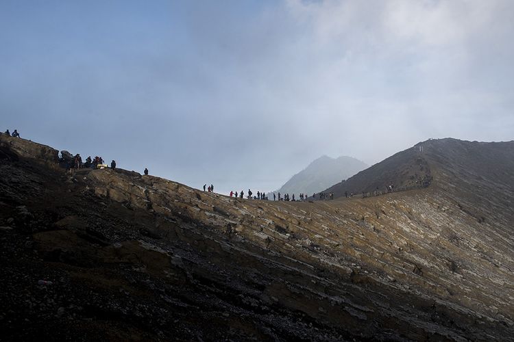 Ratusan wisatawan menikmati pemandangan dari puncak Gunung Ijen, Banyuwangi, Jawa Timur, Sabtu (23/6/2018). Kawah Ijen dengan kedalaman 200 meter menjadi salah satu dari dua lokasi di dunia yang memiliki fenomena api biru selain Islandia, membuat Ijen menjadi tujuan utama pendaki dari berbagai pelosok negeri hingga mancanegara.