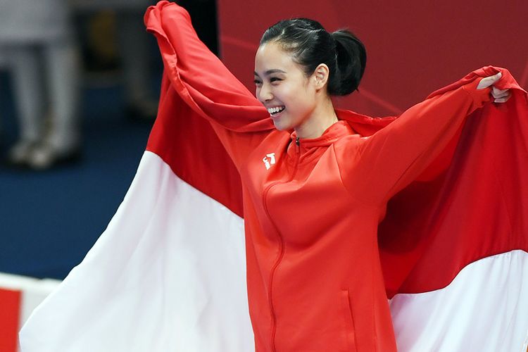 Atlet wushu Indonesia Lindswell mengibarkan bendera merah putih saat upacara penyerahan medali emas yang diperolehnya di nomor Taijijian Putri Wushu Asian Games 2018 di JIExpo Kemayoran, Jakarta, Senin (20/8/2018). Lindswell mempersembahkan emas kedua bagi kontingen Merah Putih usai berlaga dalam nomor Taijijian, meraih nilai tertinggi dengan total skor 9,75.