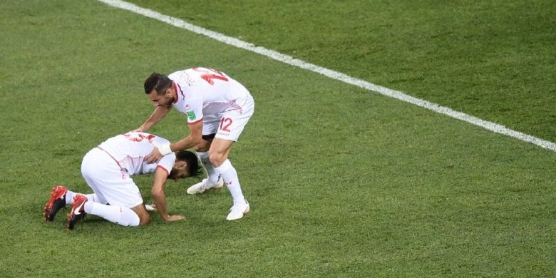 Gelandang Tunisia, Ferjani Sassi, bersyukur seusai mengeksekusi penalti ke gawang Inggris ditemani defender Ali Maaloul pada laga di Volgograd Arena, 18 Juni 2018. 