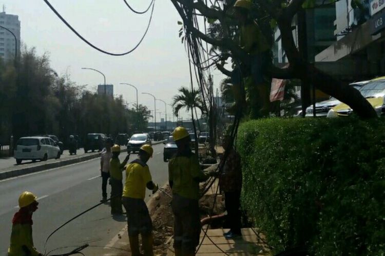 Penertiban kabel fiber optic semrawut beserta tiang penyangganya yang terpasang di sepanjang Jalan Raya Perjuangan, Kebon Jeruk, Jumat (8/9/2017).
