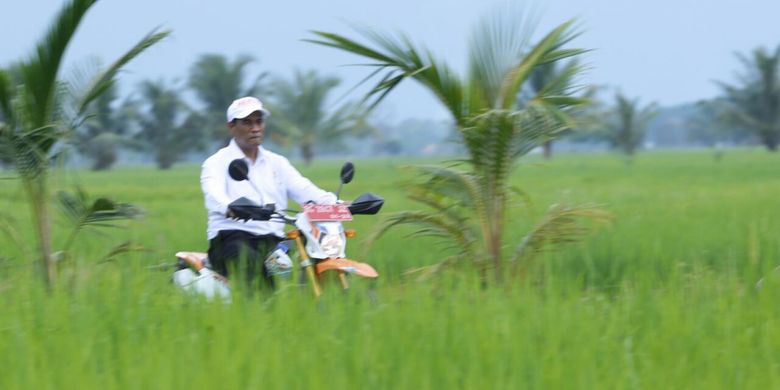 Dengan menaiki sepede motor, Menteri Pertanian Andi Amran Sulaiman meninjau lahan sawah pasang surut di Desa Telang Rejo, Kecamatan Muara Telang, Kabupaten Banyuasin, Sumatera Selatan, Kamis (6/12/2018)
