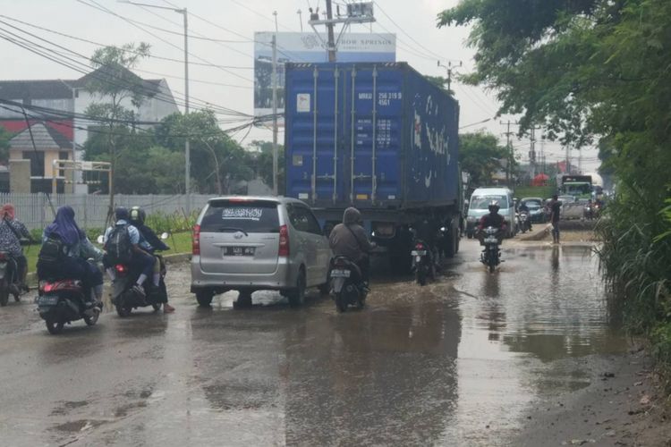 Genangan air terlihat di Jalan Raya Legok, Kab. Tangerang, Kamis (10/1/2019).